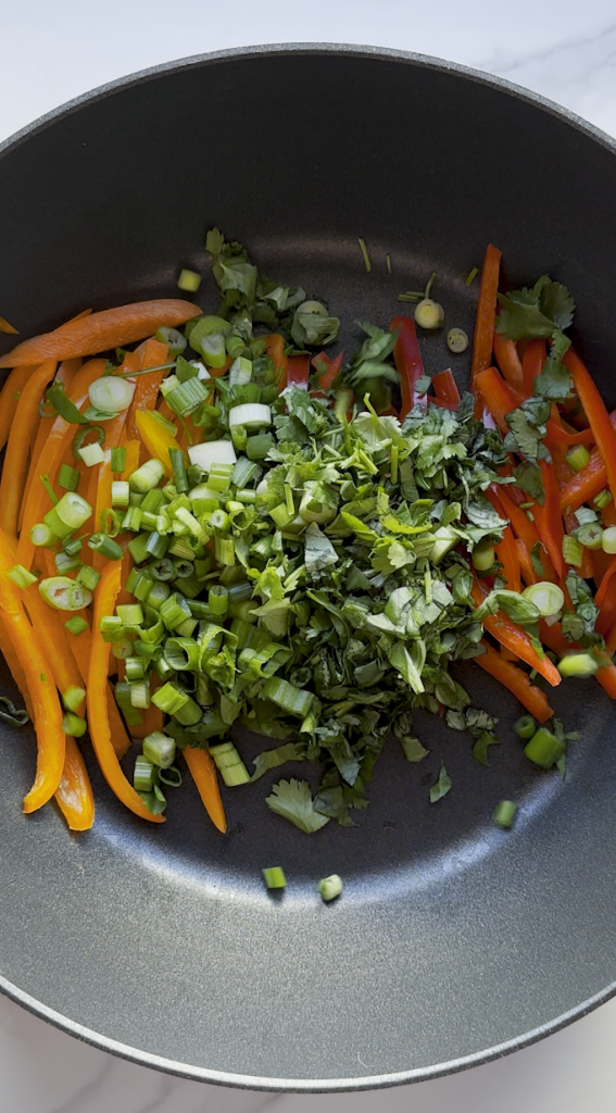 sliced bell peppers with cilantro, basil, and green onions added